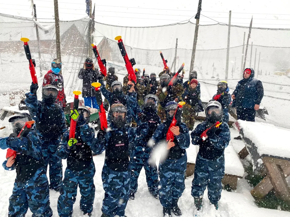 Instruktor z grupą dzieci podczas gry paintballowej